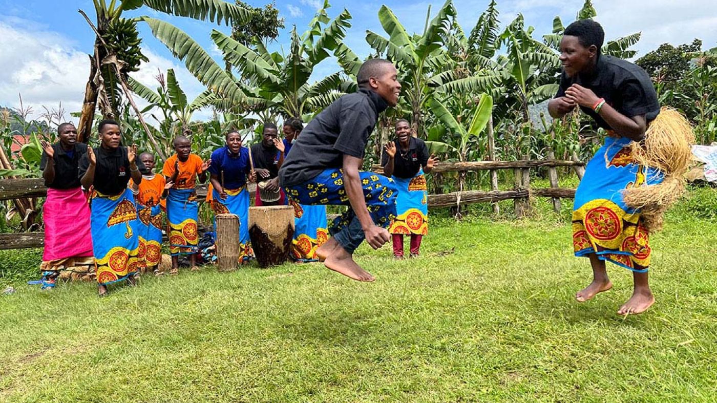 People dancing in the foreground with people playing instruments in the background.
